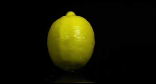 Lemon On The Black Background With Water Drops