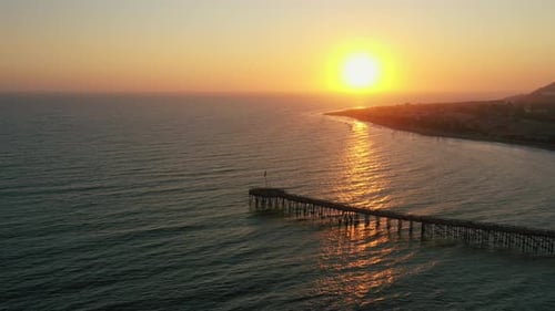 Ravishing Sunset Over The Pacific Ocean With Wooden Pier On The Coast Of California, USA. wide aeria