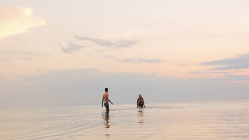 Couple Wading in Ocean at Sunset