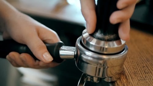 Barista Tamping Espresso Coffee Grounds Close Up
