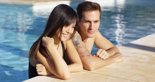 Diverse Good Looking Couple Stand In Swimming Pool