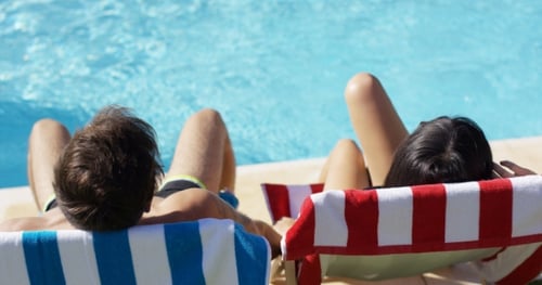 Couple Lounging Poolside on Sunny Summer Day