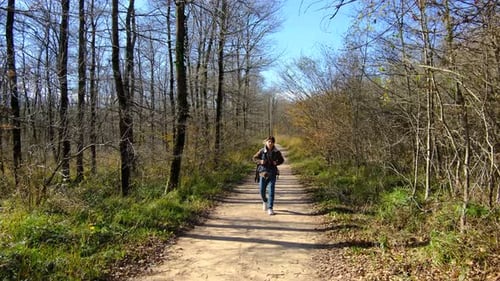 Adult Walking Down Forest Path with Backpack