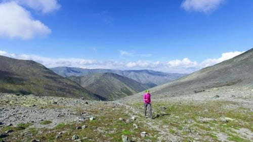 Woman Hiking in Rocky Mountain Landscape on Sunny Day
