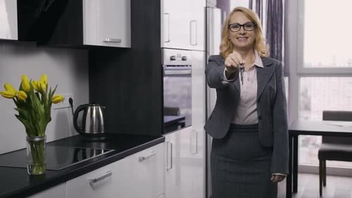 Beautiful Senior Estate Agent Showing House Keys