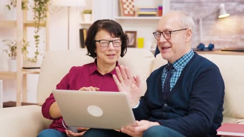 Senior Couple Video Chatting on Laptop from Home