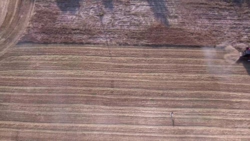 Aerial View of Combine Harvester Working in Field