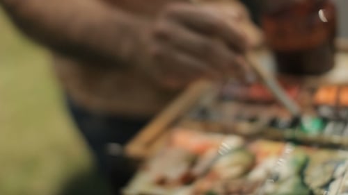 Paint Brush Dipped into Watercolor Paint Palette