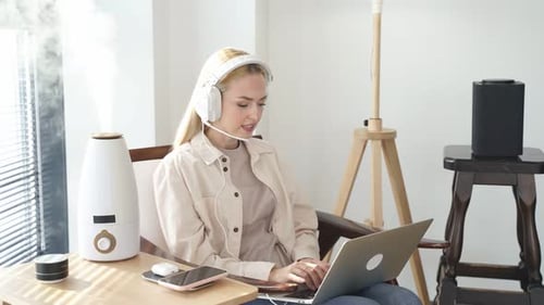 Woman in Headphones Using Laptop at Home
