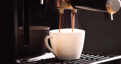 Détail d'une cafetière professionnelle faisant couler du café dans une tasse vide dans une cafétéria,