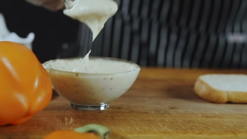 Chef Spreads Creamy Sauce on Bread Slice