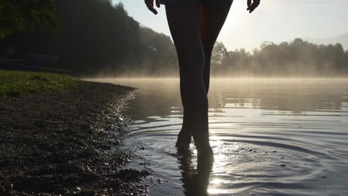 Person Wading in a Tropical Lake at Sunrise