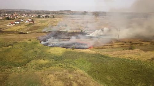 Aerial view of burning grass in field.