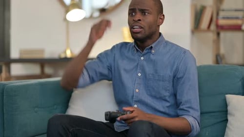 Man Playing Video Game, Reacting to Losing