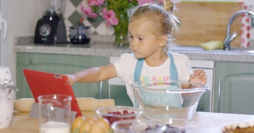 Girl Baking with Tablet in Bright Kitchen