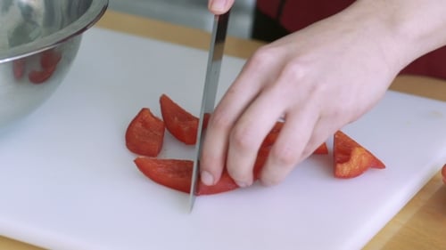 Woman Slicing Tomatoes Preparing On a Restaurant Kitchen. Slowly