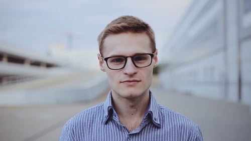 Young Adult Smiling and Making Okay Gesture