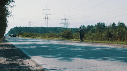 Boy Walking Along Road Hold Cardboard Plate With Sign City. Hitchhiking. Tourist