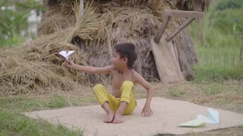 Boy with Paper Airplane in Rural Setting