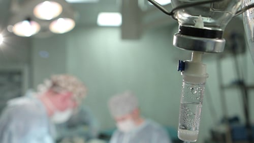 Intravenous Drip, Surgical Light and Surgeons Operating