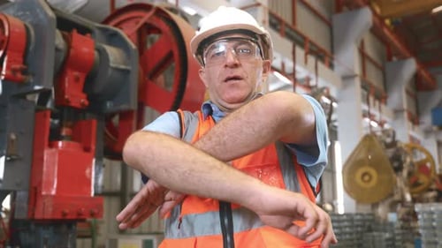 Portrait of senior man worker in safety uniform of large modern factory crossing arms on chest