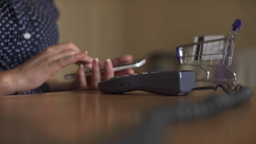 Woman Using NFC Technology When Paying In Restaurant