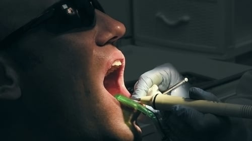 Dentist Checking Patient Teeth in Dental Office