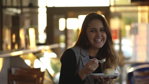 Woman Enjoys Delicious Cake at Cafe