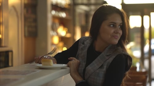 Young Woman Enjoys Cake at an Urban Cafe
