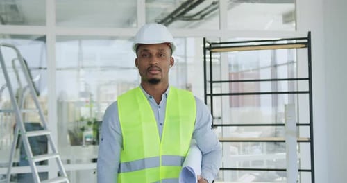 Construction Worker Holding Plans in Office Environment
