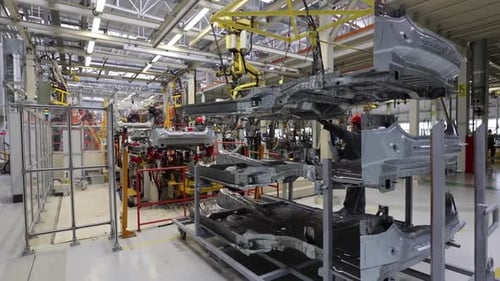 Assemblage d'une carrosserie de voiture dans une usine moderne Un travailleur de la sécurité du travail portant un casque
