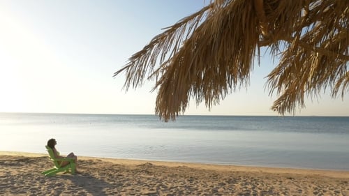 Beautiful Girl Sitting On a Chair Near The Sea