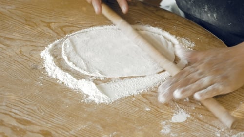 Woman Rolling Dough With a Rolling Pin