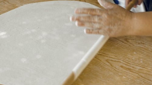 Person Rolls Out Dough with Rolling Pin