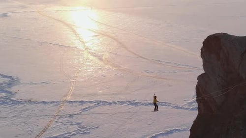 Tightrope Walker Balances on Snowy Mountain Ridge
