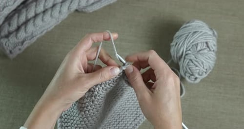 Woman Knitting Light Grey Wool Sweater at Home