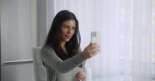 Young Woman Records Video on Smartphone at Home