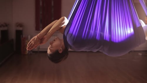 Woman Doing Aerial Yoga Inversion in Hammock