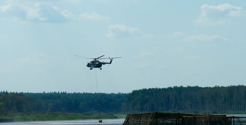 Helicopter Collecting Water From Lake in Rural Area