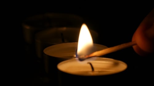 Candles Lit in Darkness with Match Flame
