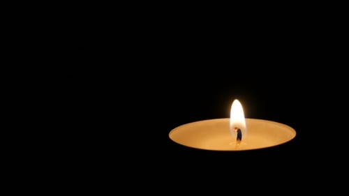 Single Candle Flame Burning in Darkness