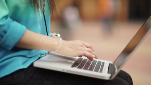 Young Adult Typing on a Laptop Computer