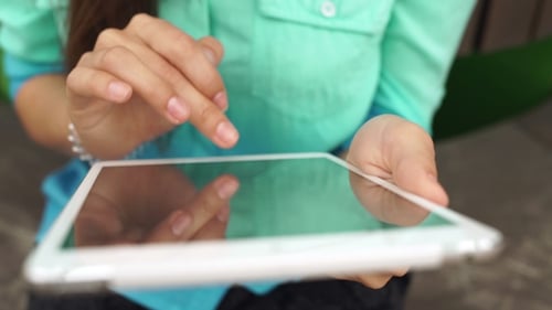 Unsichere Frau benutzt ein Touchscreen-Tablet. Das Tablet in den Händen