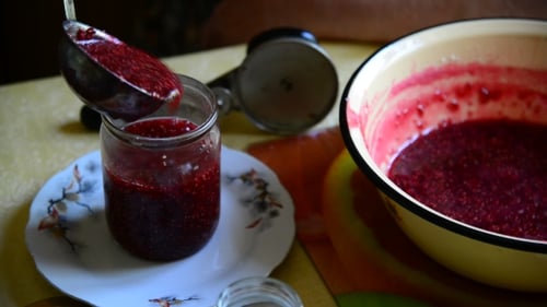 Pouring Raspberry Jam into Glass Jar
