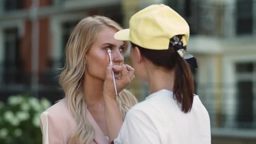 Woman Receives Makeup Assistance Outdoors