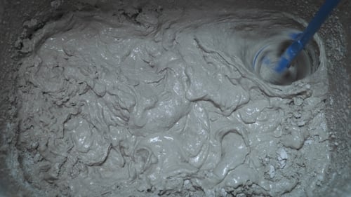 Mixing Construction Material into Smooth Gray Paste