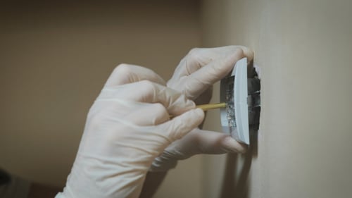 Installation des Wandlichtschalters in der Umkleidekabine mit einem Schraubendreher, Elektriker Hände