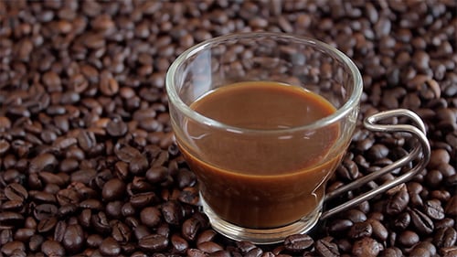 Coffee Cup Displayed on a Bed of Coffee Beans