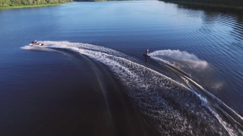 Wakeboarder Pulled by Jet Ski on a Sunny Lake