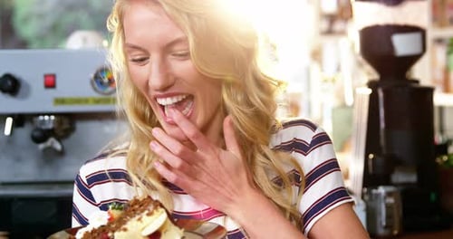 Young Woman Enjoys Cake at Cafe